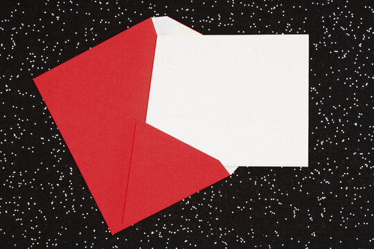 Blank greeting card with red envelope on black sparkle felt