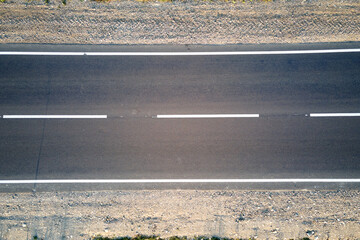 Aerial view of empty intercity road at sunset. Top view from drone of highway in evening
