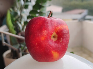 closeup of a worm hole in a red apple
