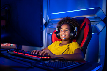 Professional gamer with headset playing or streaming online video games on computer. Children addicted to entertainment industry. - obrazy, fototapety, plakaty