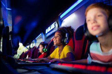 Professional group of gamers playing video games together in tournament. Children enjoying entertaining industry.