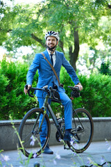 Obraz premium Bearded businessman in suit and helmet with bike
