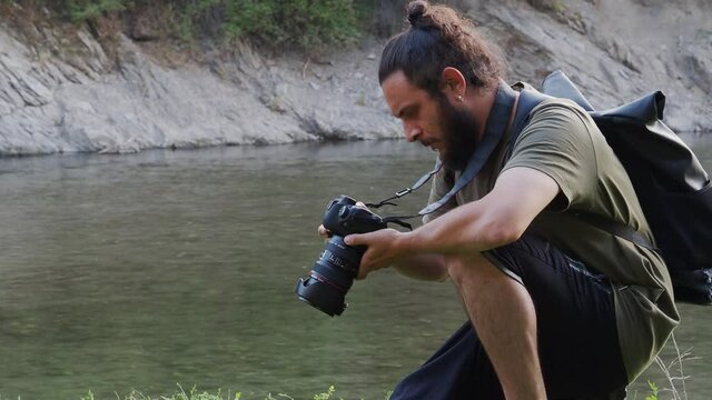 Adventurous man taking photos in nature. Landscape photographer