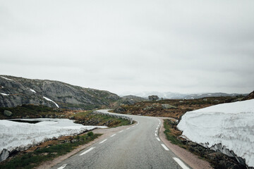 Late winter road over the mountain with melting snow
