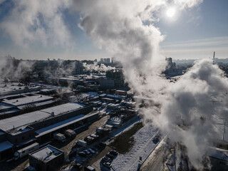 Aerial view from a drone to the factory and to air pollution in the city