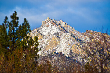 Fototapeta na wymiar Stunning tall snow covered mountain peak on sunny blue sky day