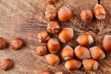 Heap of hazelnuts in shell isolated on wooden background