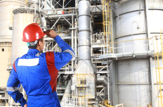 chemical industrial engineer standing under industrial pipe