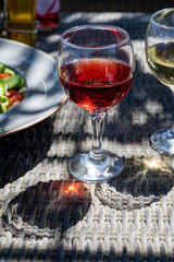 Two glasses of cold rose and white wines in lounge bar on sunny day