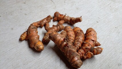 Freshly turmeric is laid out on a wooden board. Selective focus.