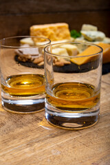 British drinks and food, glasses of Scotch whisky and cheeses collection, blue Stilton, Scottish coloured and English matured cheddar cheeses