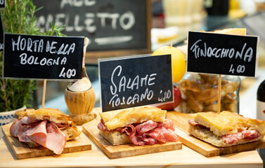 Italian street food, Parma ham sandwiches, bread with cured meats in market in Florence, Italy...