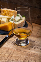 British drinks and food, glasses of Scotch whisky and cheeses collection, blue Stilton, Scottish coloured and English matured cheddar cheeses