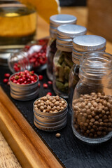 Professional set of gin spices in small bottles, pink pepper, hibiscus flowers, juniper berries, cardamom and coriander seeds