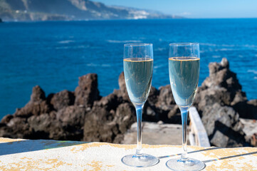 New year celebration with two glasses of champagne or Spanish cava sparkling wine and view on blue Atlantic ocean, Canary islands, winter tourists destination