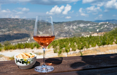 Wine industry of Cyprus island, tasting of rose dry wine on winery with view on vineyards and south slopes of Troodos mountain range.