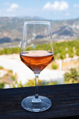 Wine industry of Cyprus island, tasting of rose dry wine on winery with view on vineyards and south slopes of Troodos mountain range.