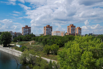 Fototapeta na wymiar View of the city of Ust-Kamenogorsk (kazakhstan). Old residential area. Soviet built multistory apartment buildings. Irtysh river. Green trees and blue sky