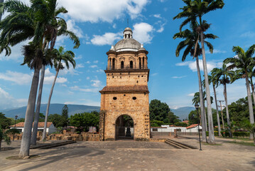 Fototapeta premium Bell tower of the historic temple of Villa del Rosario surrounded by palm trees. Cucuta. Colombia