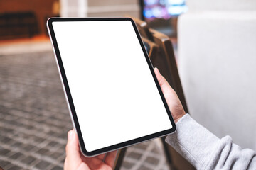 Mockup image of a woman holding digital tablet with blank white desktop screen in the outdoors
