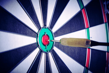 Concept achieving goal .Achieving goals in business and life.Dartboard with dart stuck right in...