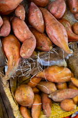 Raw sweet potato in basket displayed for sale in greengrocery