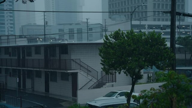 A wide shot of a rain storm that doesn't let up in a city neighborhood.