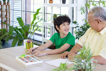 Retired grandfather teach his  grandson to draw and color during the holidays. Enjoy leisure weekend at home. Stress free concept
