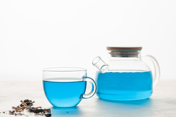 Obraz na płótnie Canvas Thai blue Anchan tea in a glass cup and teapot on a white background.