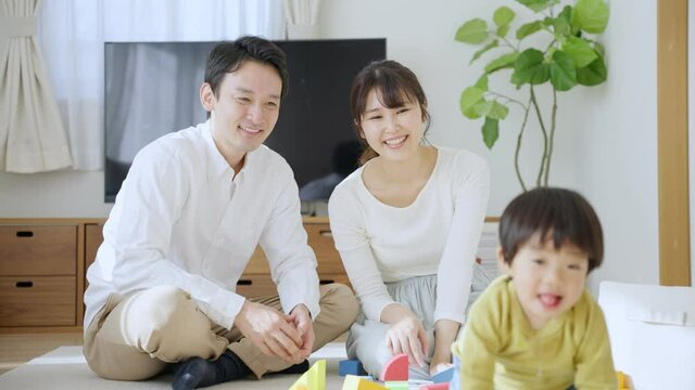 60p　積み木で子供と遊ぶ両親（育児・子育て・家族・ファミリー）