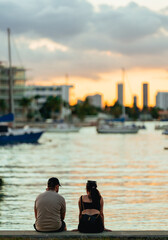 couple on the pier at sunset Miami Beach horizon buildings boats sea 