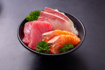 Sashimi Set (Raw Salmon, Hamachi and Bluefin Tuna) sliced and put together in a black bowl and ready to served. Popular Japanese food.