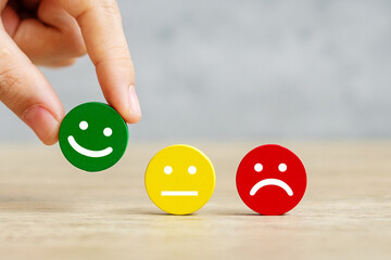 hand holding emotion face block. Customer choose Emoticon for user reviews. Service rating,...