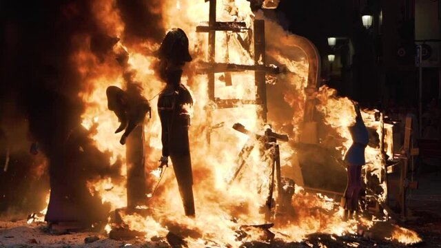 Falla with caricatures burning during the night of the Crema in Valencia, Spain. Slow motion.