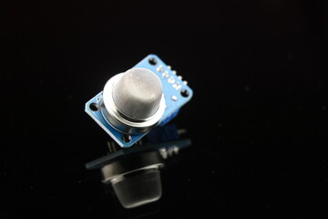 Side view of MQ2 gas sensor module isolated on reflective glass black background