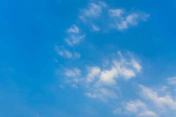 Naklejka na ściany i meble Bright blue sky with white fluffy clouds