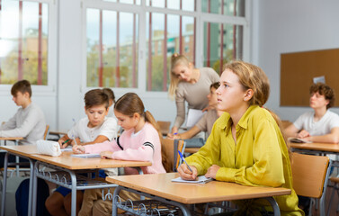 Teenage students are sitting at their desks in classroom