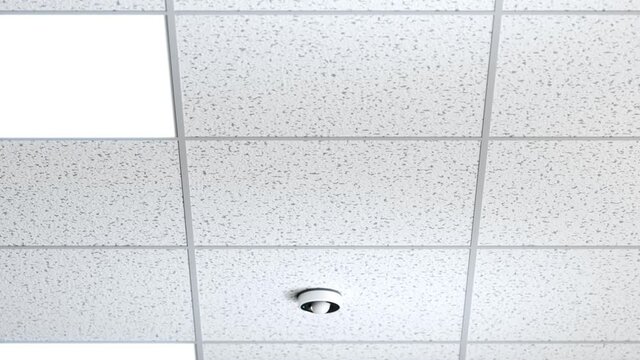 Loopable animation of grid ceiling with motion sensor devices. Turning lights on
