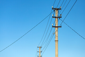 Fototapeta premium Interlacing electric wires with lights against the sky. Silhouette of a pillar