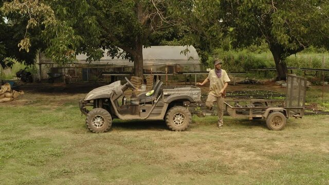 Farmer loading an utv all terrain vehicle in a farm with seeds and plants, transport