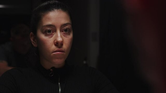 Portrait of young woman upset stares into nothingness, dark scene, static