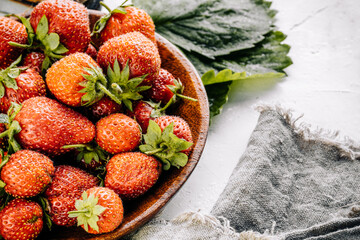 Red strawberries on a light wooden background