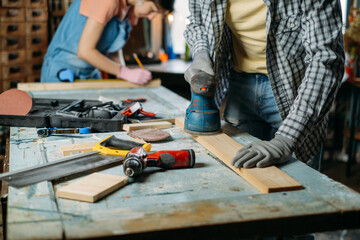 Man and woman working in workshop, doing furniture, reuse old materials to new product. awareness in consumption. Small family business. Recycling, sustainability refurbishments maintenance for home