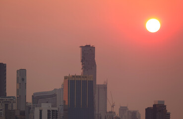 Bangkok City Skyline with the Bright Sun Shining on Gradient Orange Sky