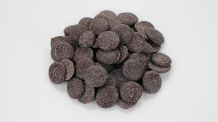 Dark chocolate chips on white background. Chocolate chips. Confectionery concept