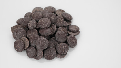 Dark chocolate chips on white background. Chocolate chips. Confectionery concept