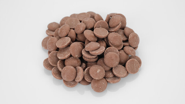Milk chocolate callets on white background. Chocolate chips. Confectionery concept