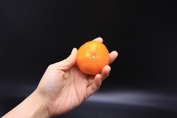 귤을 들고 있는 여자의 손
