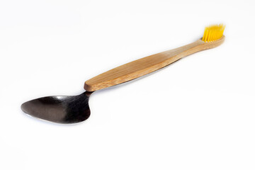 Spoon and wooden toothbrush on white background. Concept of dental hygiene.
