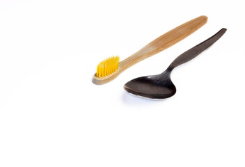 Concept of dental hygiene. Spoon and wooden eco tooth brush in the corner with copy space